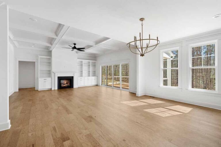 Open dining and family room with a fireplace and a wall of windows in The Augusta