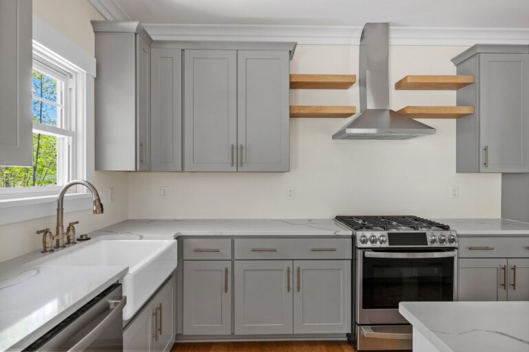 Kitchen with gray cabinets, a farmhouse sink and a stainless range in The Augusta