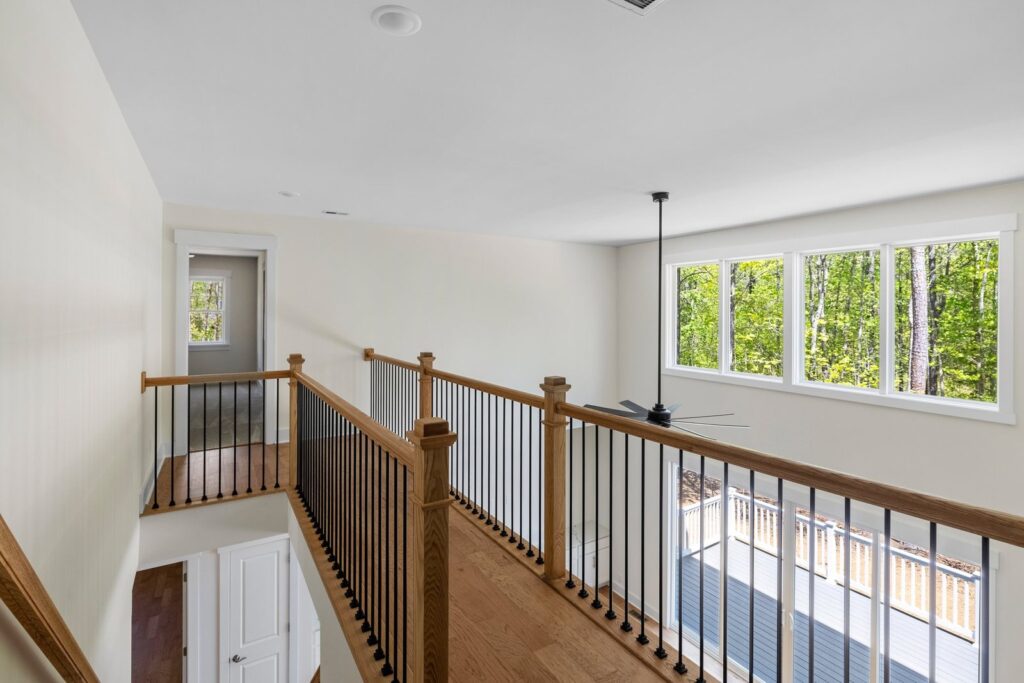 Upstairs loft with a wood railing in The Augusta