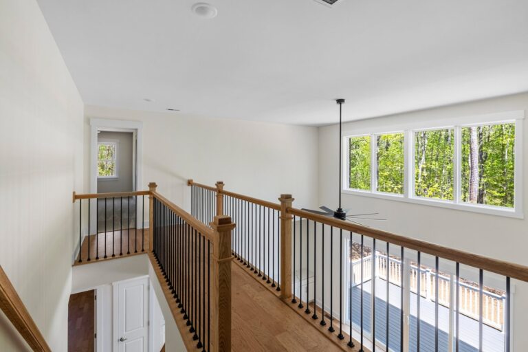 Upstairs loft with a wood railing in The Augusta
