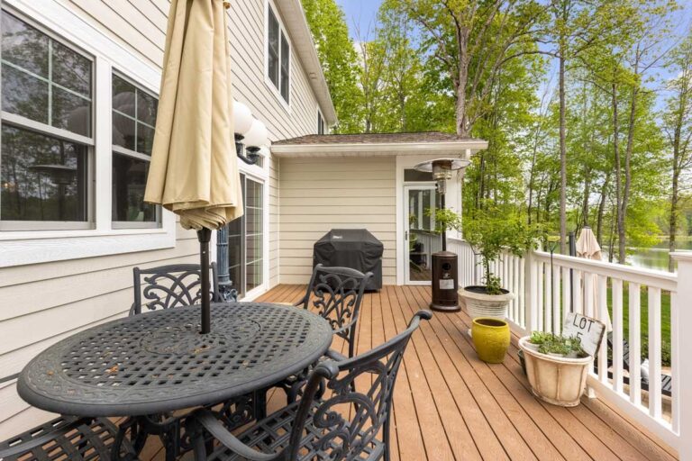 Deck with a dining table and lake view in The Hogan