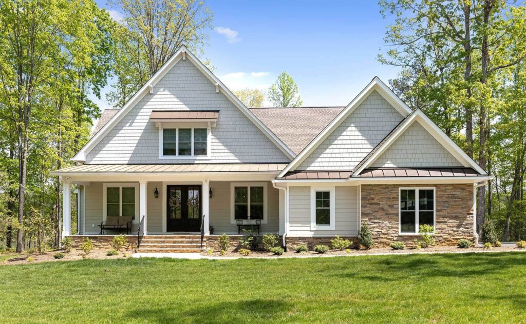 The Hogan, a gray craftsman-style Ridout custom home with stone accents on Maple Lake Road in Maple Grove, Powhatan