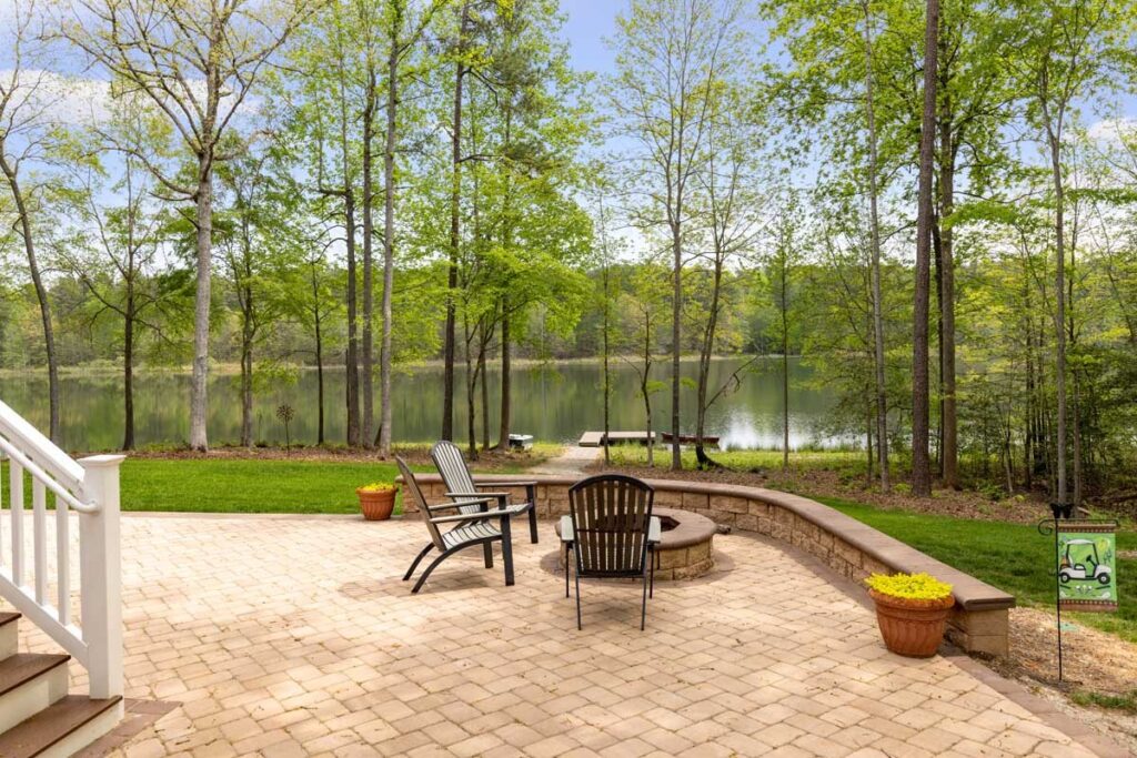 Paver patio with a fire pit by the lake in The Hogan