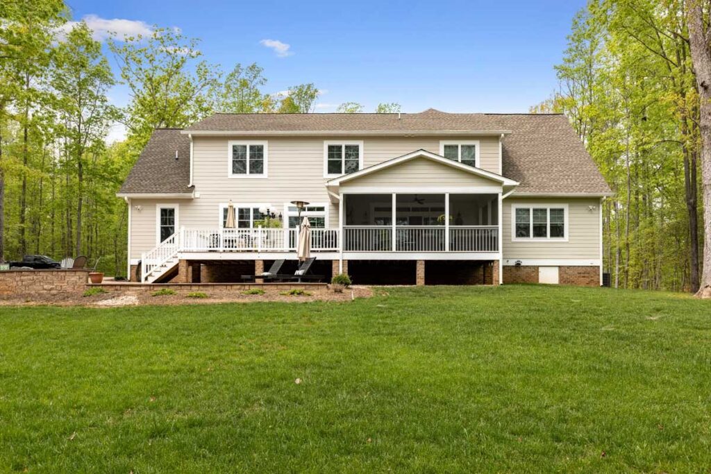 Rear of The Hogan with a screened porch and deck facing the lawn