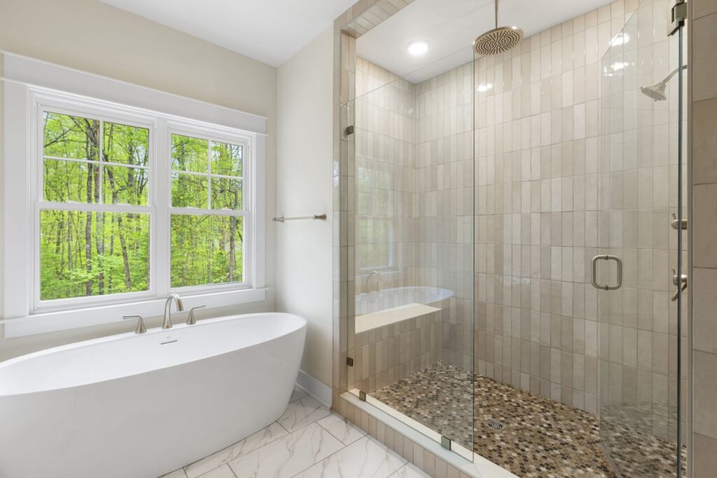Primary bath with a freestanding tub and a glass shower in The McIlroy
