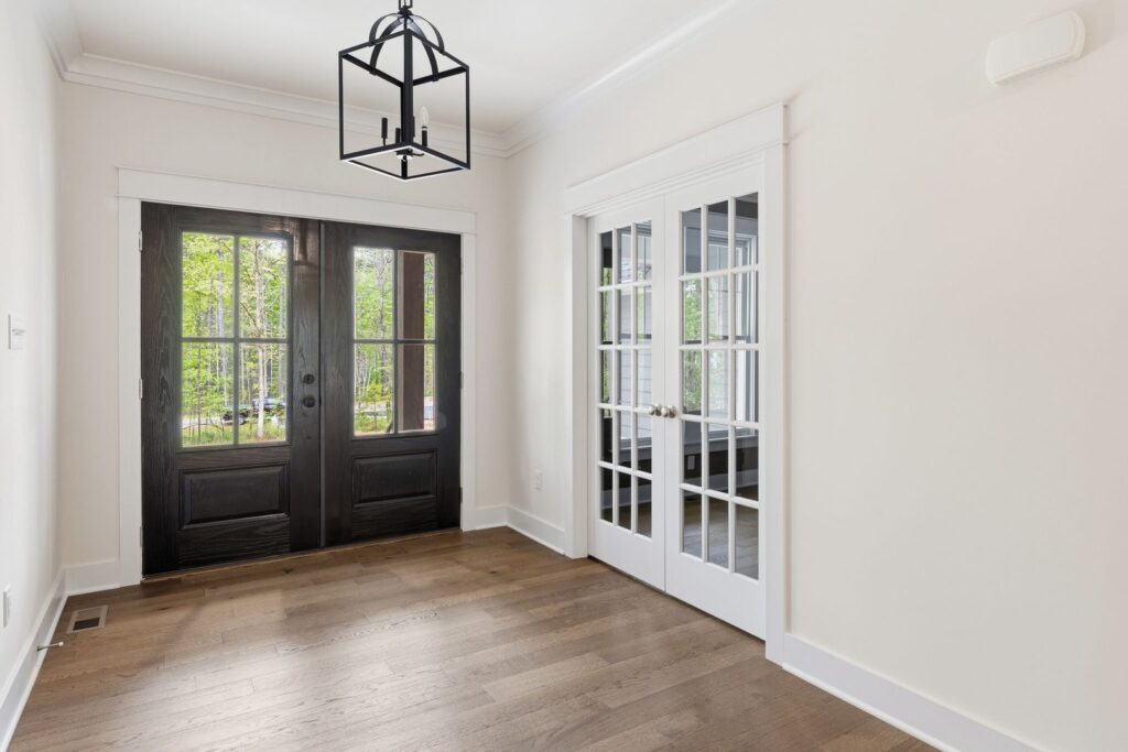 Entry with black double doors and a lantern pendant in The McIlroy