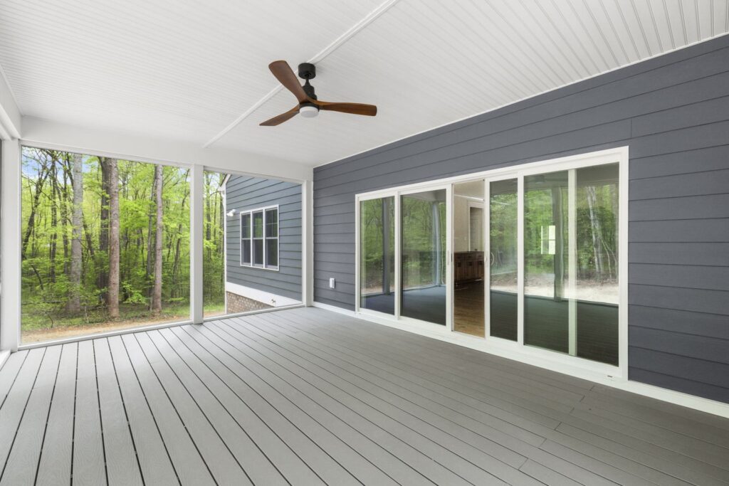 Covered rear porch with a ceiling fan and sliding doors in The McIlroy