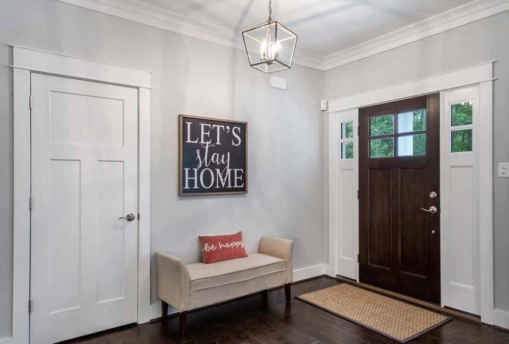 Foyer with a bench, a dark front door and a lantern pendant in The O'Meara