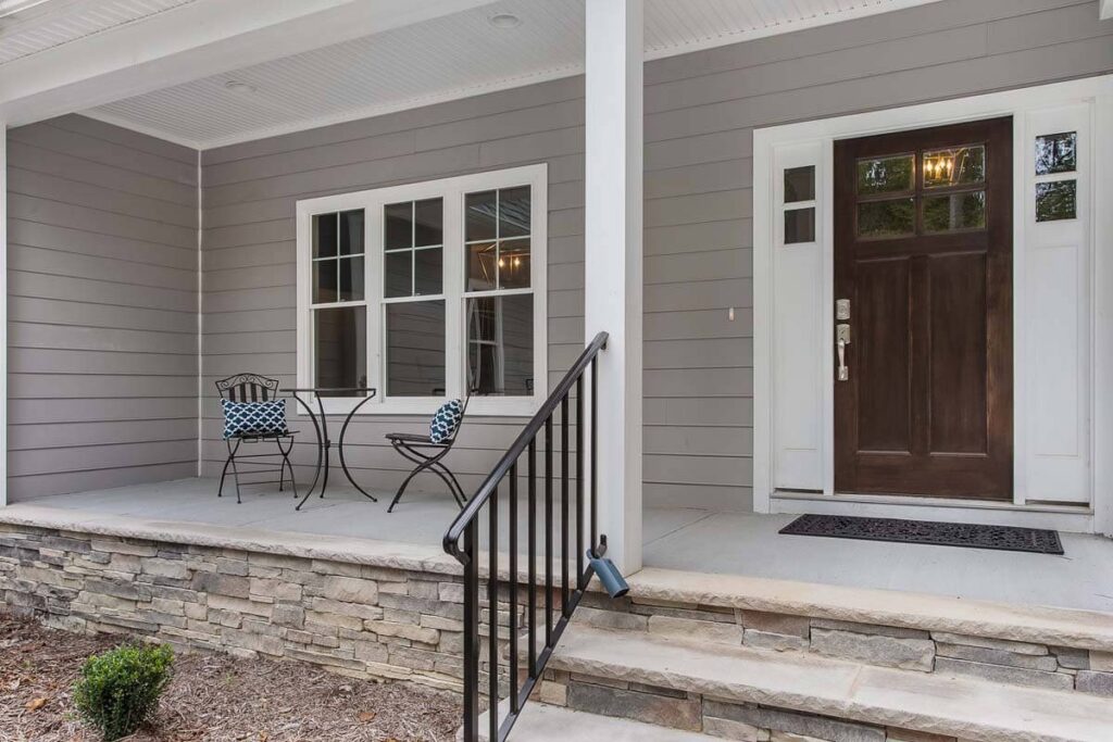 Front porch with rocking chairs and a stone foundation in The O'Meara