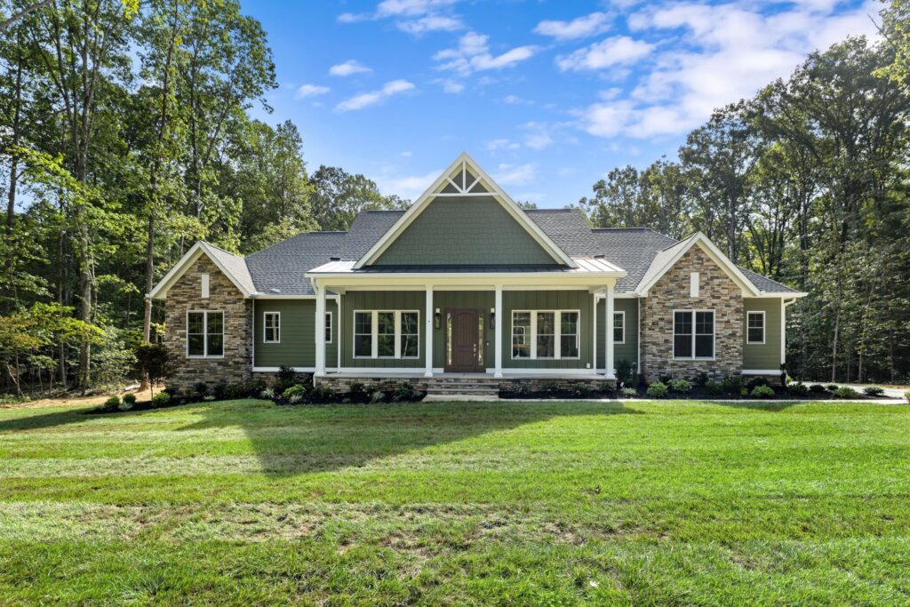 The Palmer, a green craftsman-style Ridout custom home with a stone foundation on a wooded lot in The Trails at Huntington Estates, Powhatan