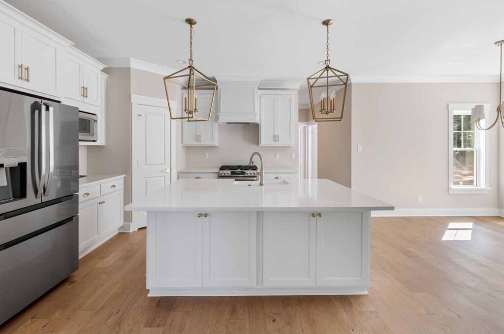 White kitchen with a large island and stainless appliances in The Player