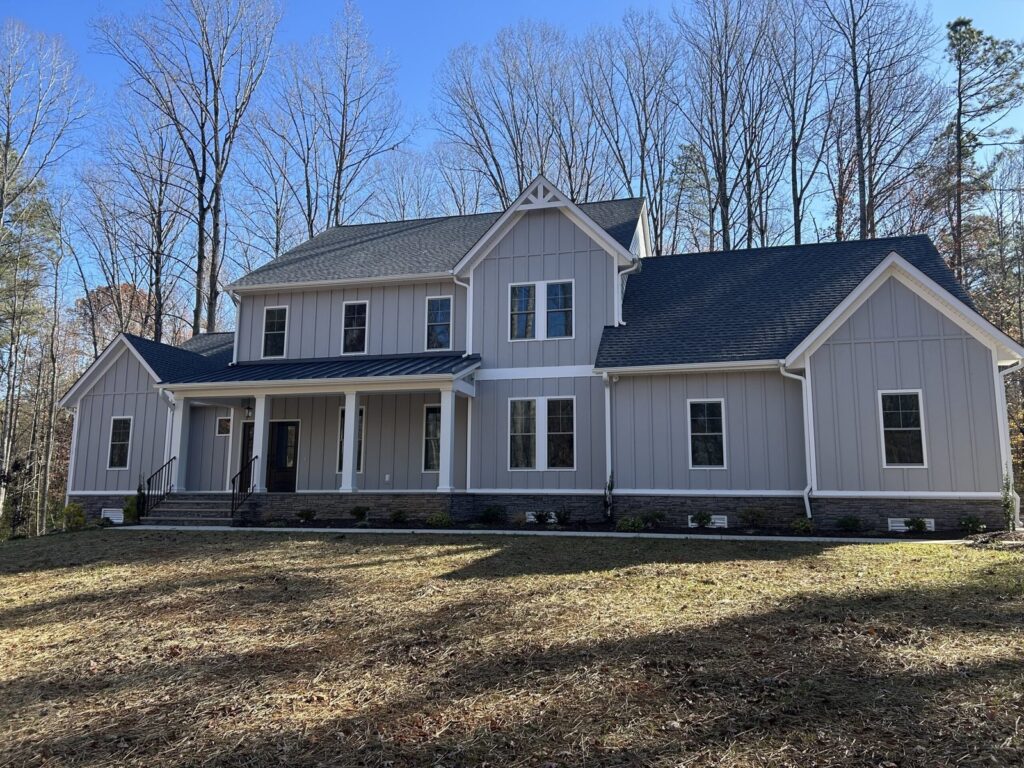 Front porch of a gray Scheffler with a white door and stone steps