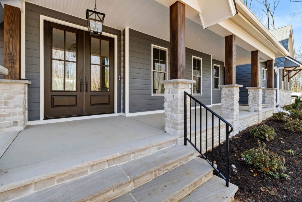 Front porch with double doors, a wood ceiling and stone columns in The Scheffler