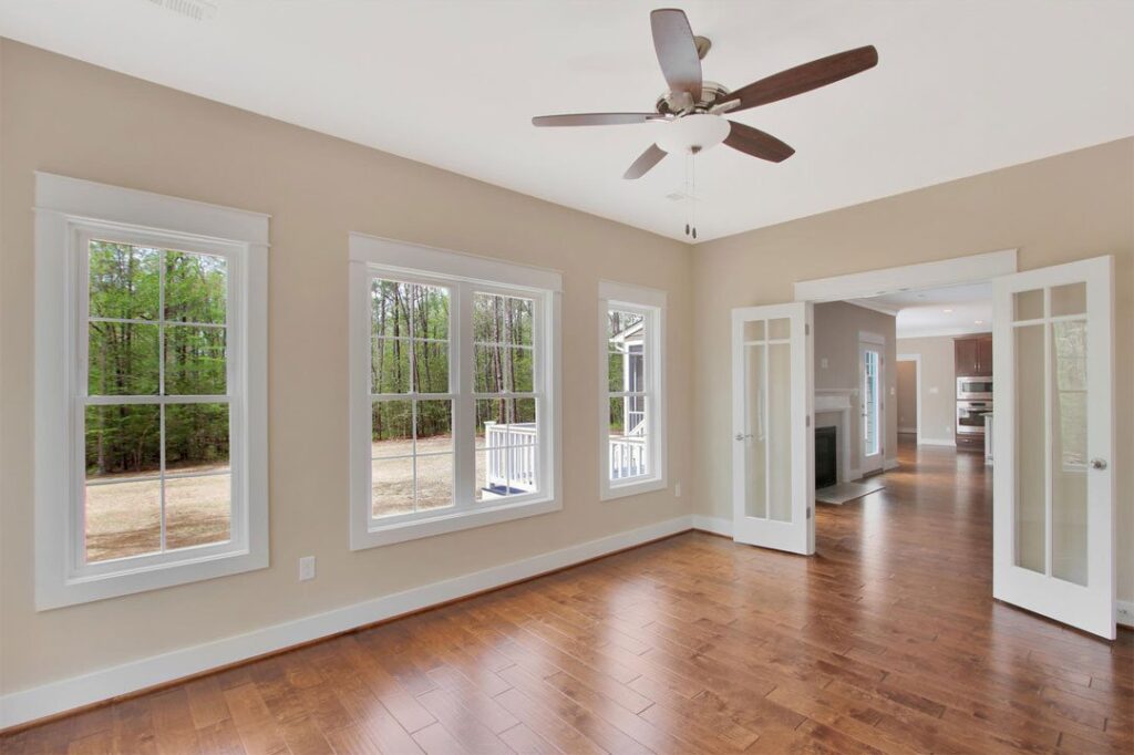 Sunroom with a wall of windows and hardwood floors in The Watson